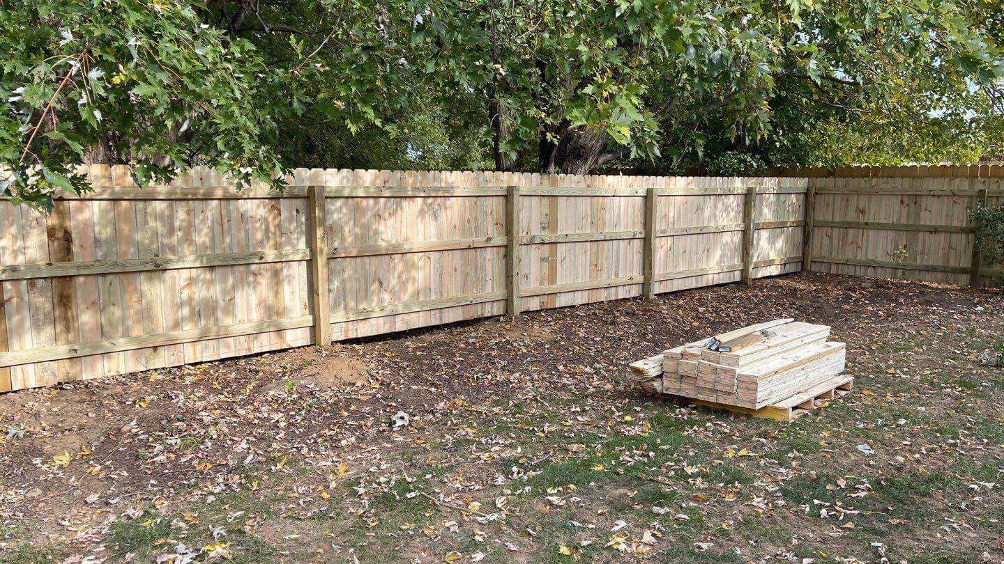wooden-picket-wall-privacy-fence-with-big-trees-on-the-background-in-newark-de